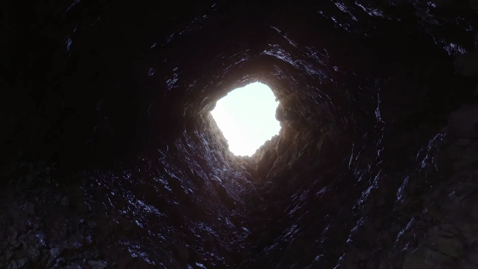 Looking up from the bottom of a freshly dug grave at a ragged patch of daylight